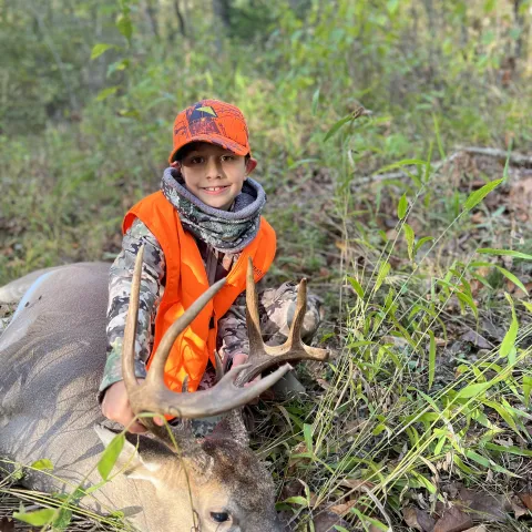 Young boy pictured with harvested deer.