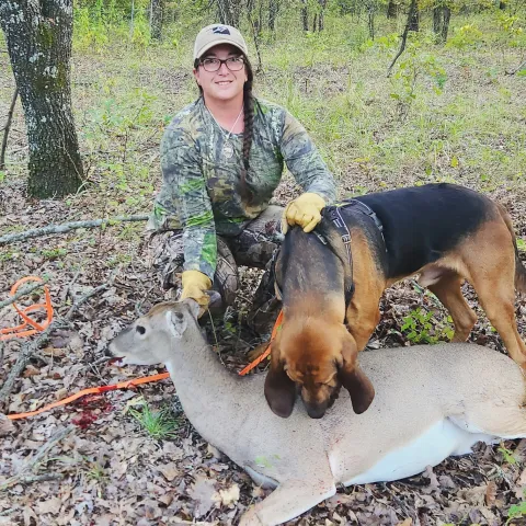 Hunter pictured with dog and harvested deer.