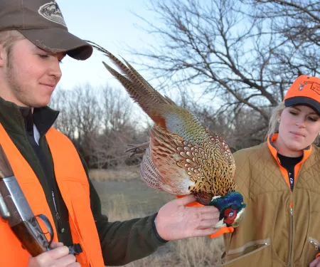 Two hunters with a pheasant.