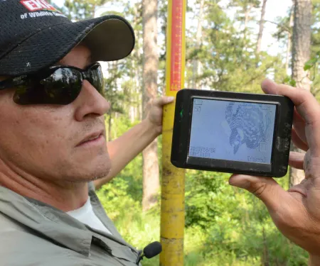 Biologist Clay Barnes with camera monitoring Red-cockaded woodpecker at the McCurtain County Wilderness Area.