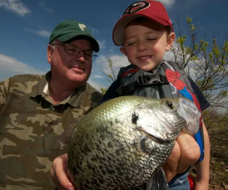 Man and boy admire caught crappie.