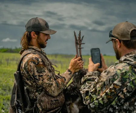 Two men are checking in their harvest turkey after a hunt.