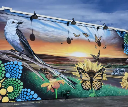 A mural showing a scissor-tailed flycatcher, monarchs, and an American bison along Route 66
