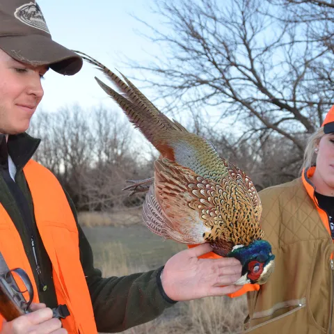 Two hunters with a pheasant.