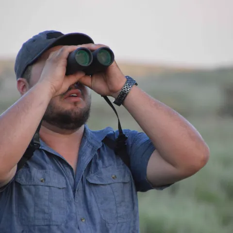 Wildlife viewer looking through binoculars.