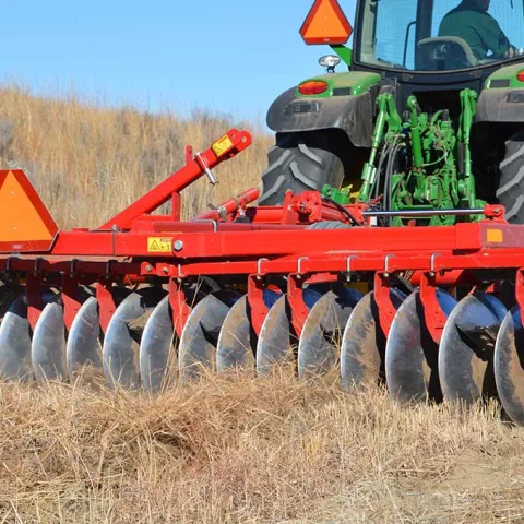 Tractor disc on field.