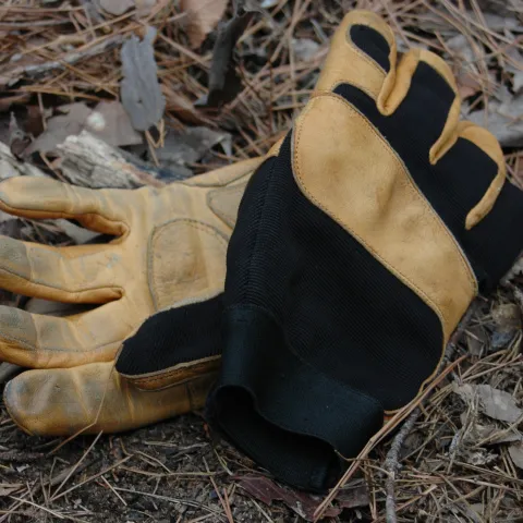 a pair of leather and black fabric gloves