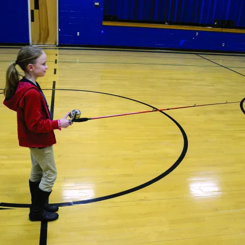 A girl casting a fishing rod. 