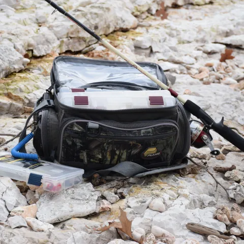 A tackle box, tackle bag, and fishing pole sitting together. 