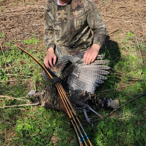 man with turkey with long bow