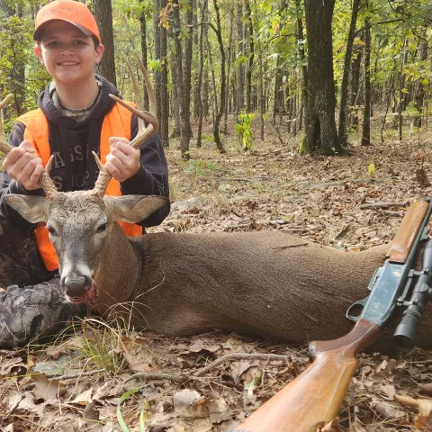 young man with harvested buck