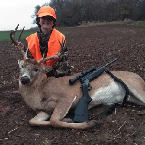 Young hunter pictured with harvested deer.