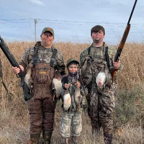 3 hunters pictured with harvested waterfowl birds.