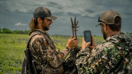 Two men are checking in their harvest turkey after a hunt.