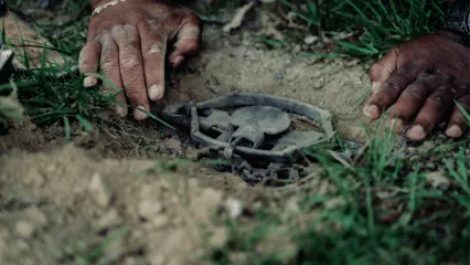 A photo of hands setting a trap.