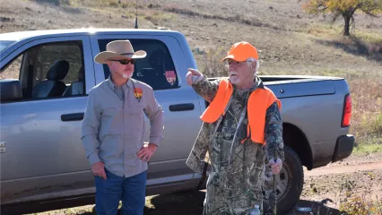 A biologist and a hunter have a conversation in the field. 