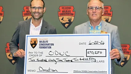two men holding a large check