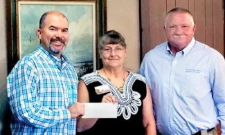Laura McIver, Oklahoma and Texas regional representative for Quail Forever, presents a check representing donations from three QF chapters to Wildlife Department Director J.D. Strong (left), and Wildlife Division Chief Alan Peoples for equipment and upland game conservation activities at two WMAs.  [DON P. BROWN / ODWC]