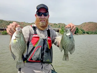Fisheries technician John Perry holds several crappie that turned up during recent fish sampling surveys at Lake Altus-Lugert in southwestern Oklahoma. Biologists report that the lake is again a viable fishery after toxic golden algae blooms in 2012 and in 2014.