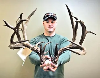 Travis Ocker of Lawton holds the nontypical rack that scored 245 2/8, putting him in the third-place overall whitetail spot in the Cy Curtis Awards Program. (PROVIDED BY GEORGE MOORE)