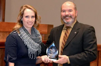 Holding the 2020 Governor's Communications Effectiveness Award is Information and Education Specialist Kelly Adams and Wildlife Department Director J.D. Strong. The award honored promotional efforts for the Hunters Against Hunger program. (Don P. Brown/ODWC)