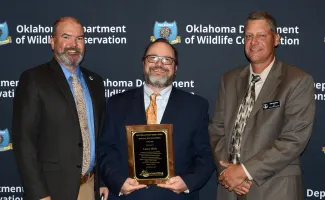 Gathered for presentation of a Special Recognition Award from the Southeastern Association of Fish and Wildlife Agencies are, from left, ODWC Director J.D. Strong, Education Senior Specialist Lance Meek (honoree), and Communication and Education Chief Nels Rodefeld. (Don P. Brown/ODWC)