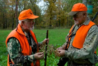 Two hunters examine a batch of acorns. 