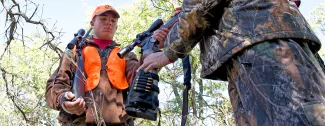 Youth hunter safely handing off firearm to another hunter.  Photo by legendary ODWC photographer Steve Webber.