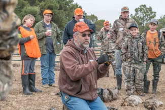 A person teaches a group about trapping techniques. 