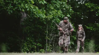 A father and daughter go small game hunting in the woods.