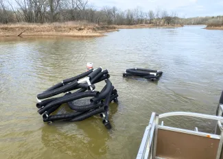 PVC fish habitat structures are sinking into a lake.