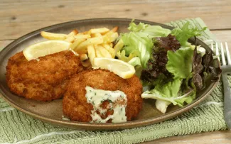 A plate with a couple of fish cakes, and a salad.