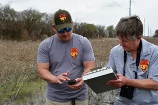 Two men record information about a turtle during a field survey.
