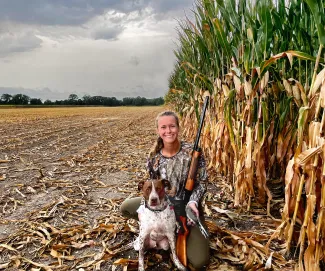 Woman hunter posing with hunting dog