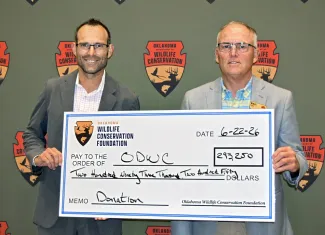 two men holding a large check